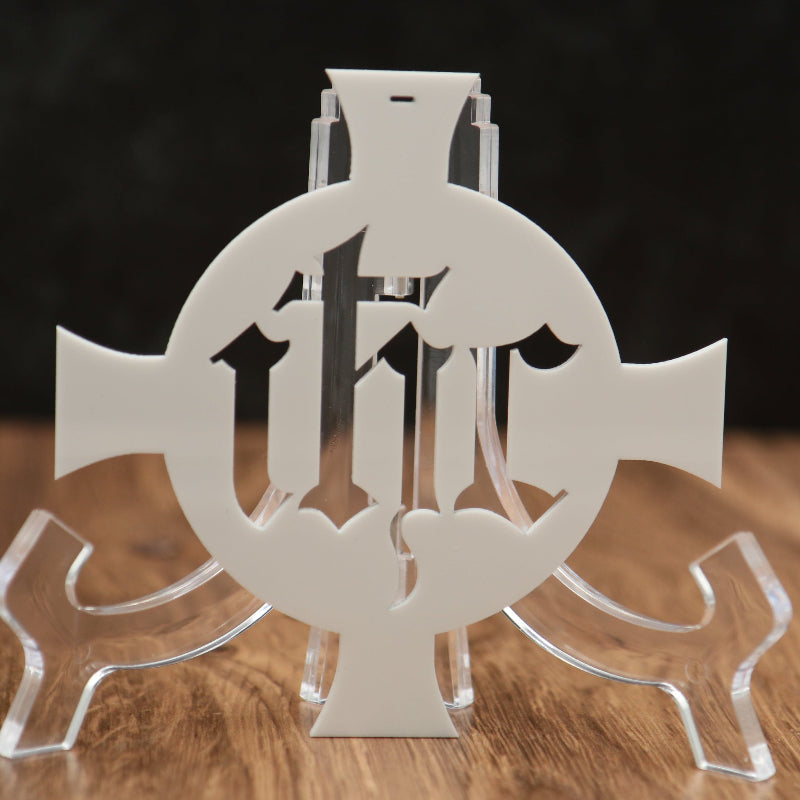 A clear acrylic decorative stand featuring a central cutout design with the letters 'I', 'H', and 'C' arranged in a circular motif, displayed on a wooden surface against a dark background.